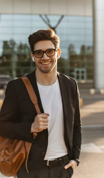 happy-businessman-in-eyeglasses-looks-into-camera-and-smiles-sincerely-brunette-guy-in-black-jacke.jpg